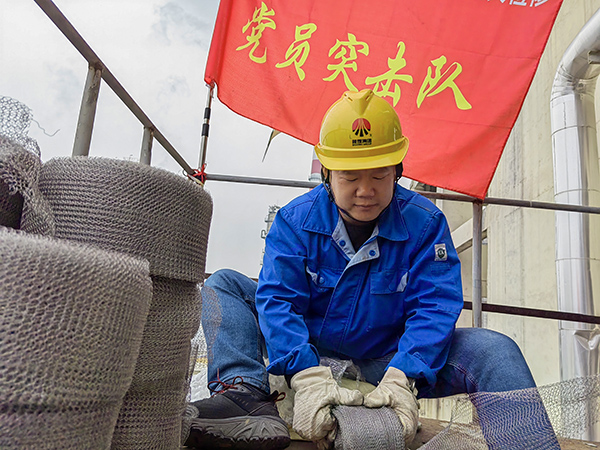 5月10日中午，在動力車間三期工藝除氧器平臺上，黨員突擊隊隊長李鑫正在纏繞新填料.jpg