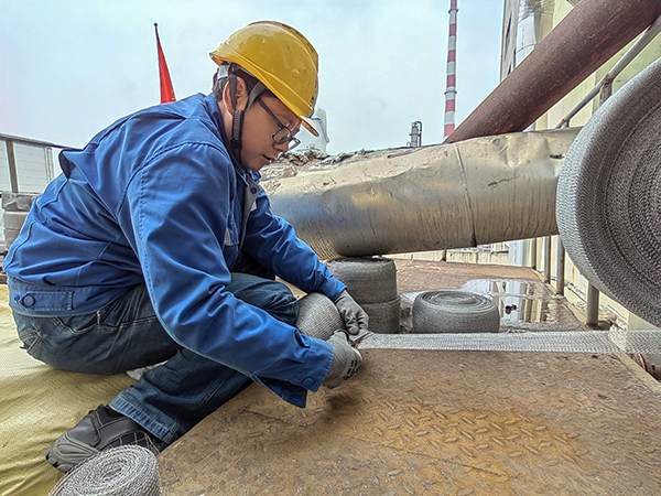 5月10日中午，在動力車間三期工藝除氧器平臺上，黨員突擊隊隊員劉瑞斌正在纏繞新填料.jpg