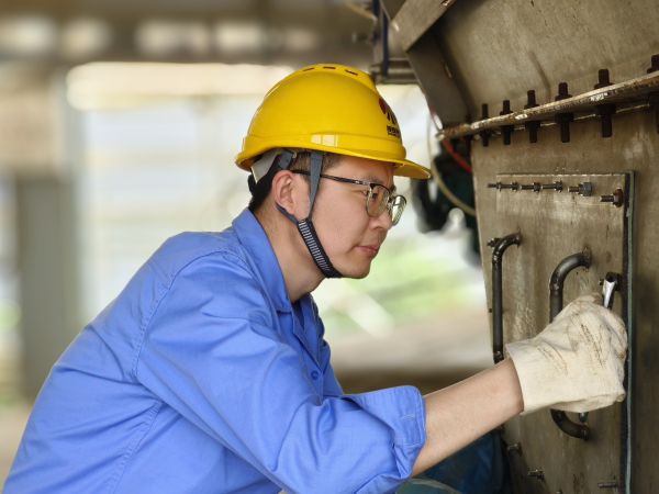 5月11日，尿素車間設(shè)備技術(shù)員馬強(qiáng)檢查設(shè)備螺栓是否松動(dòng).jpg